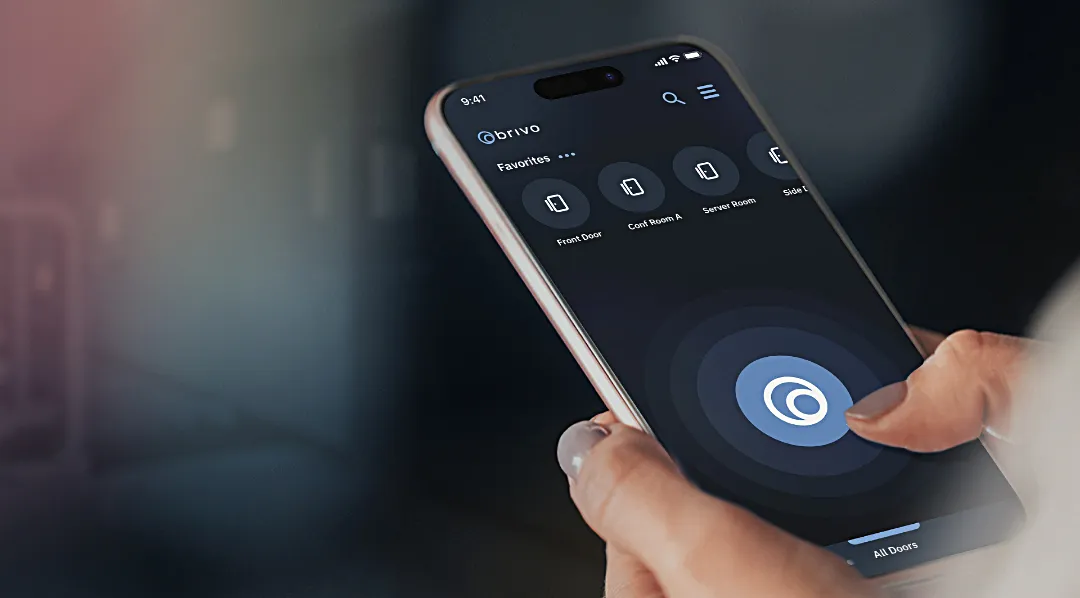 Hand holding smartphone using Brivo mobile pass to unlock a door